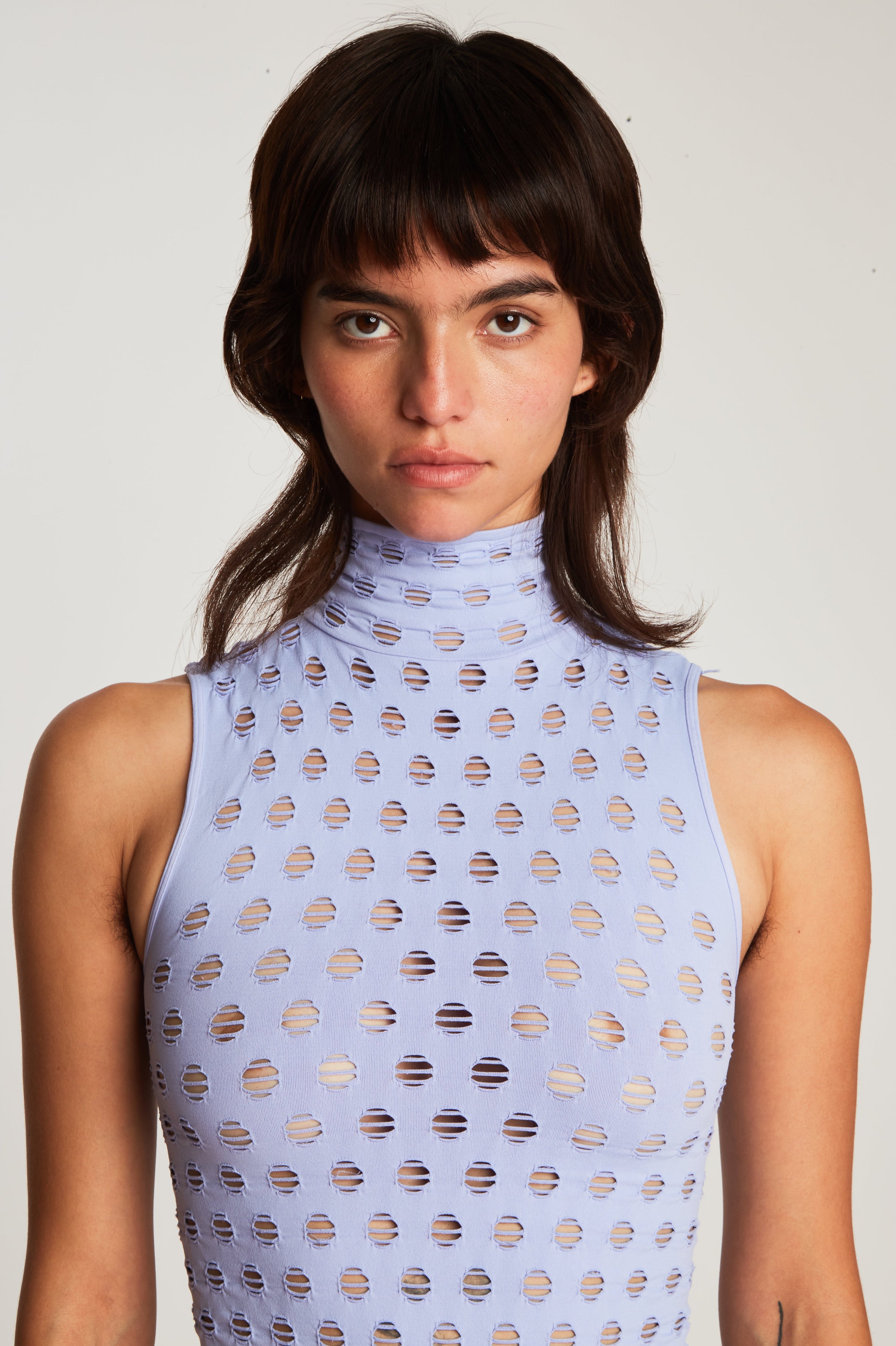 Perforated sleeveless turtleneck