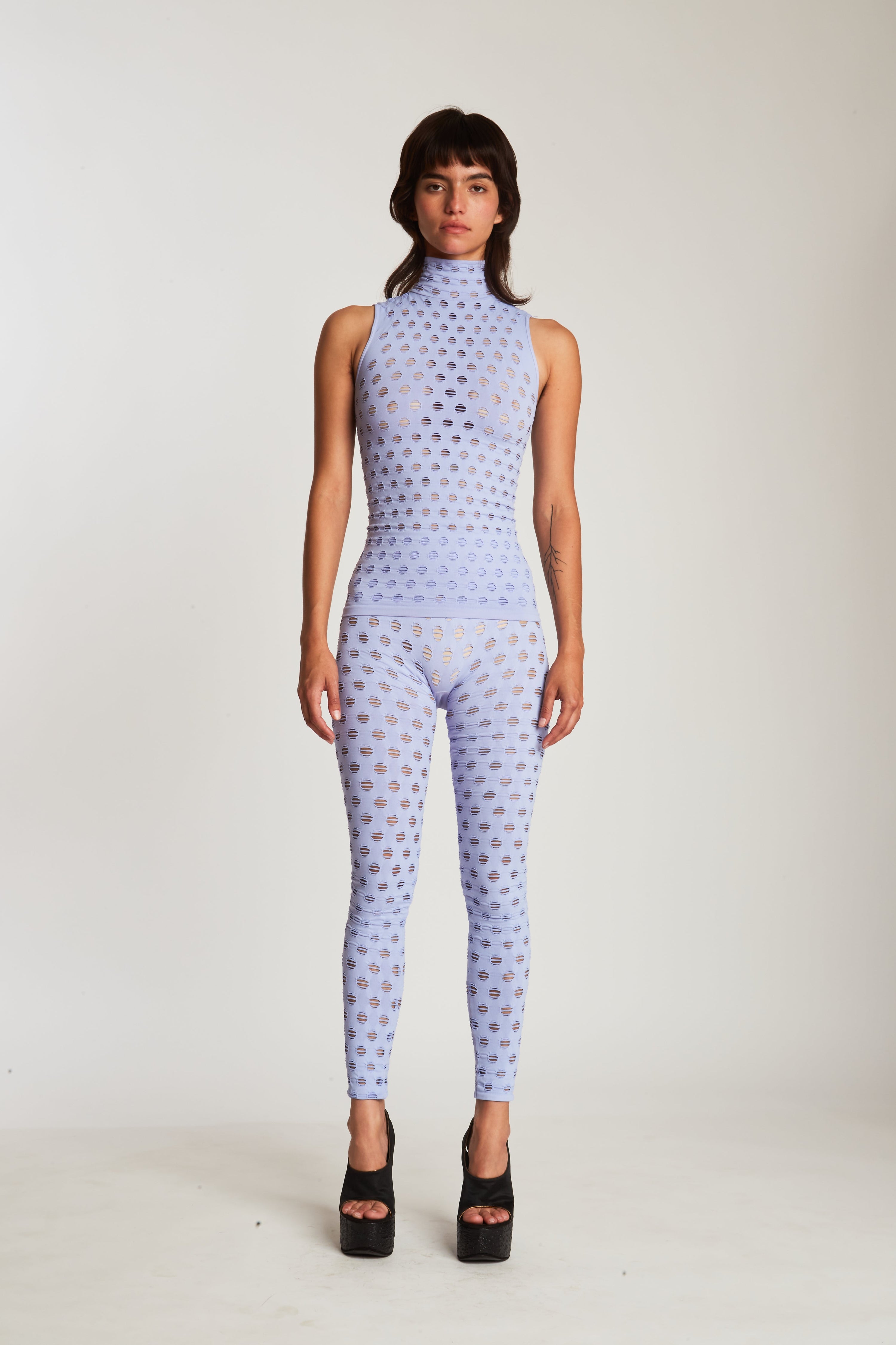 Perforated sleeveless turtleneck