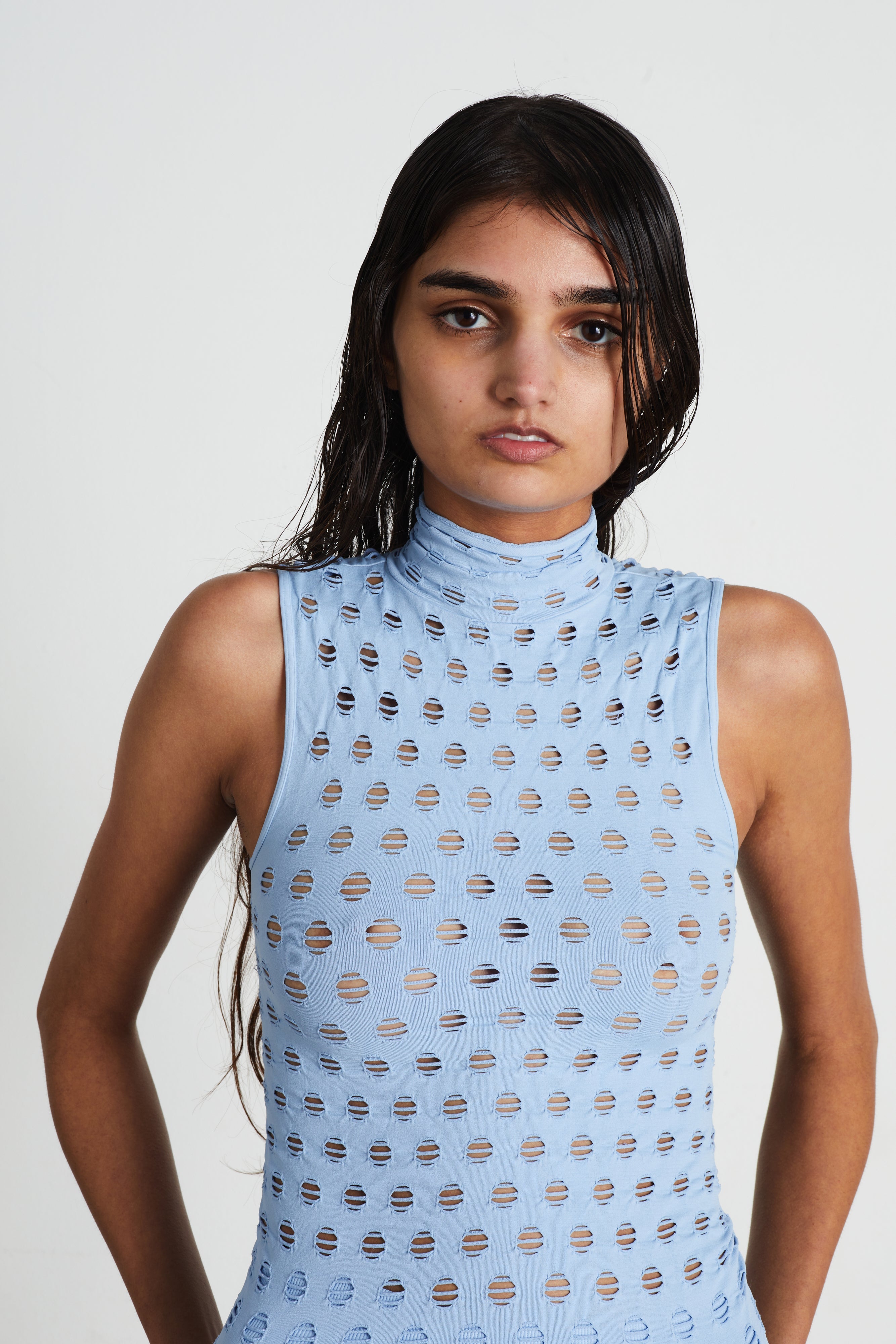 Perforated sleeveless turtleneck