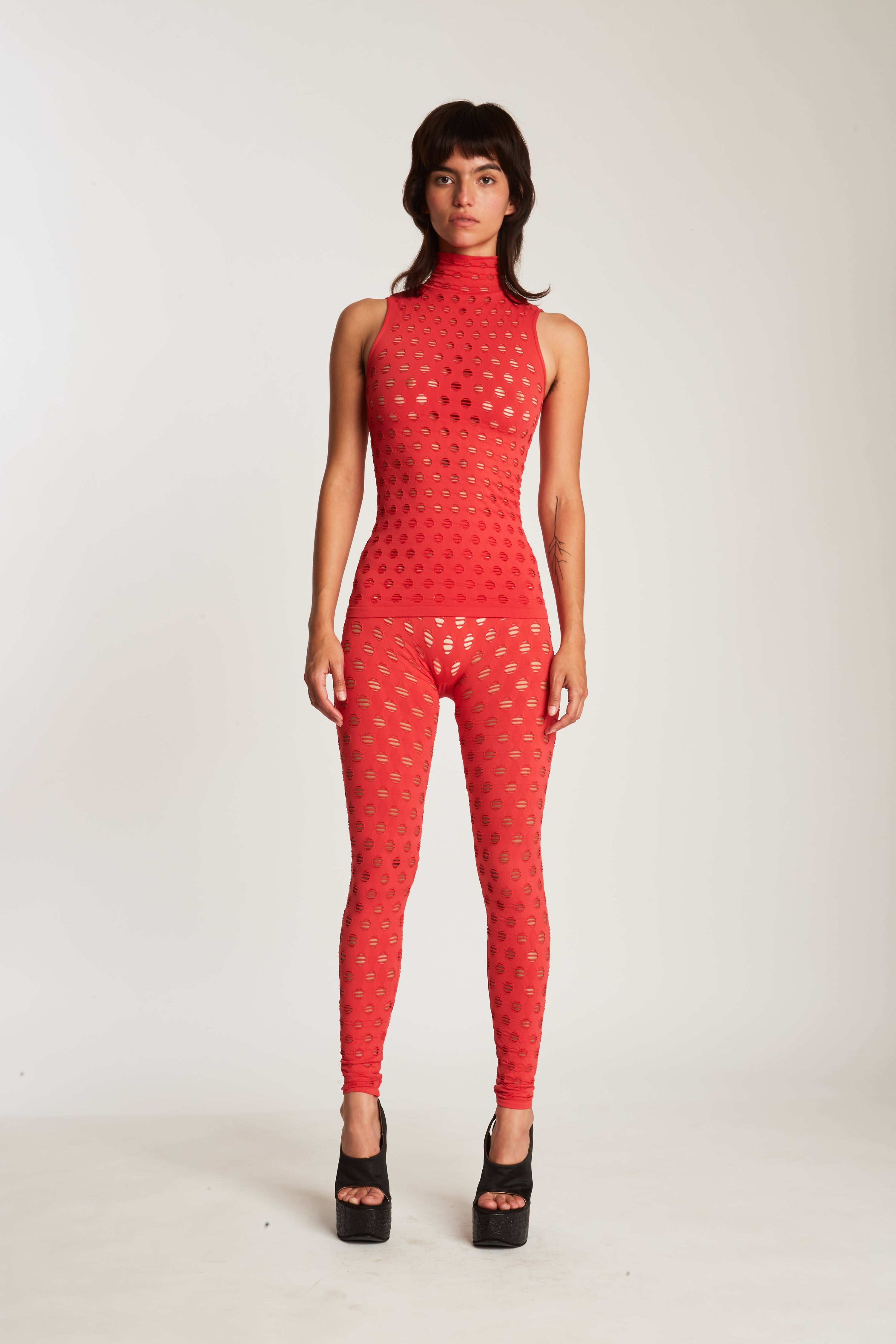 Perforated sleeveless turtleneck