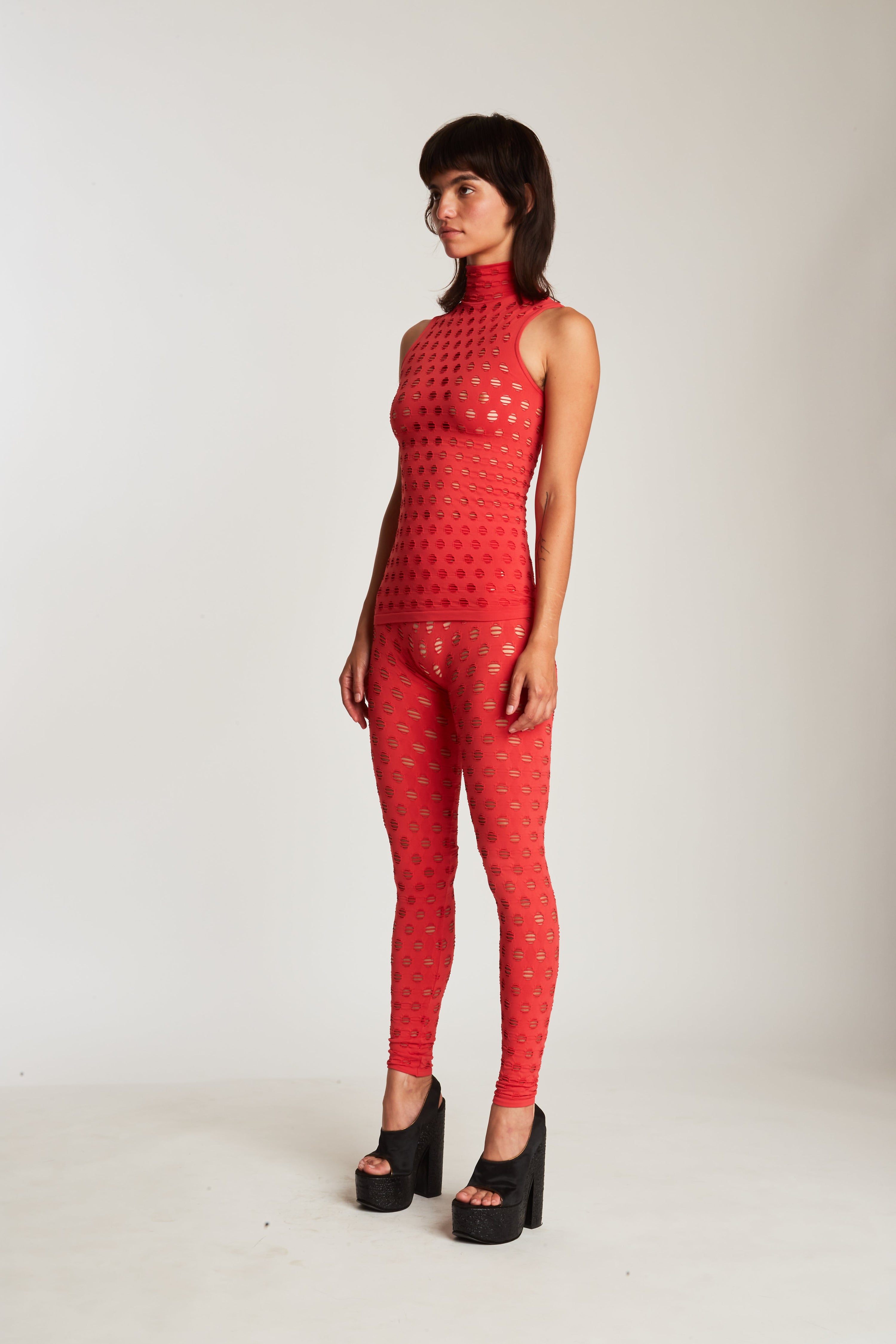 Perforated sleeveless turtleneck