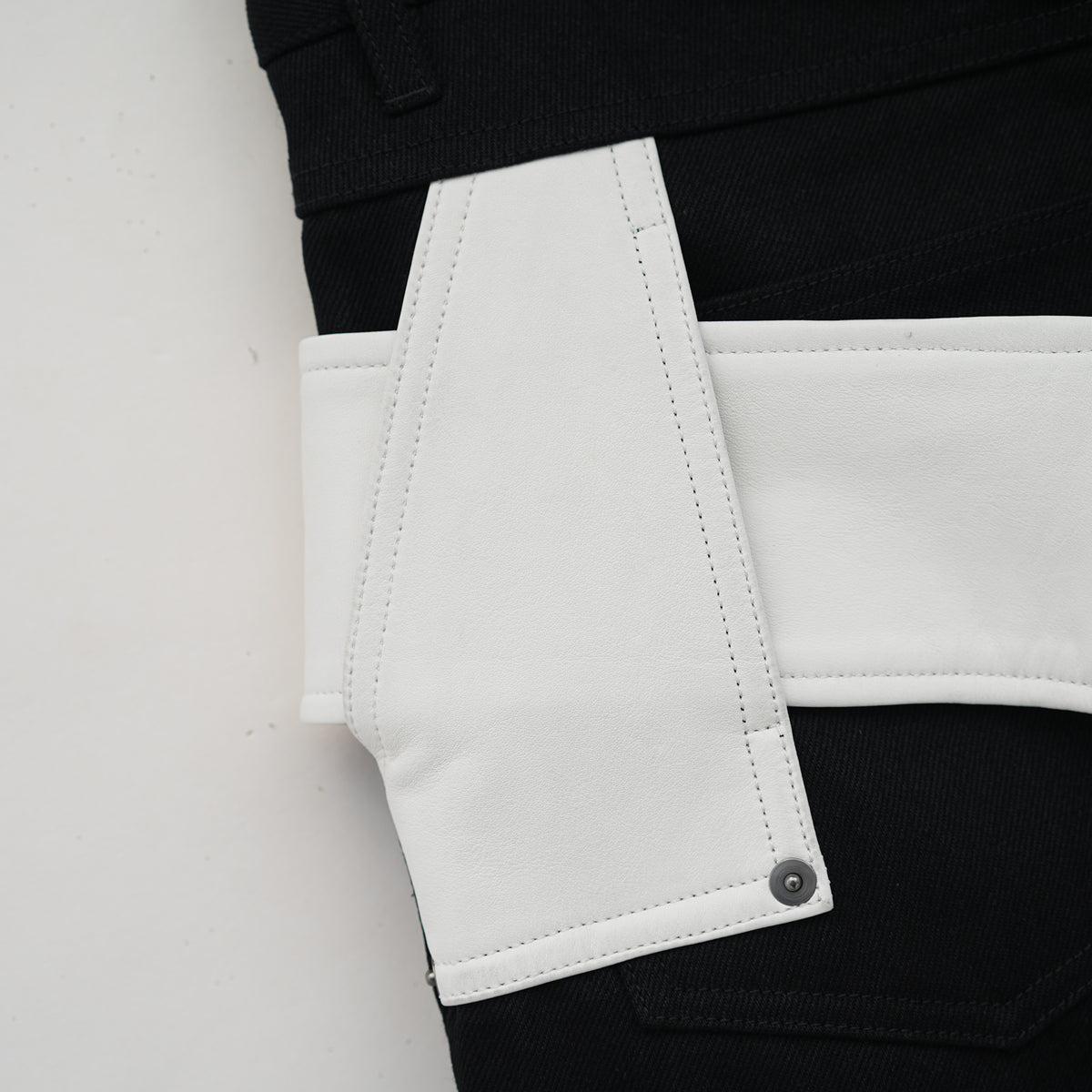 Belted leather-panel jeans